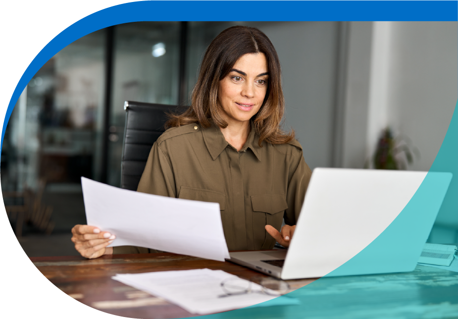 woman in front of the computer holding a document